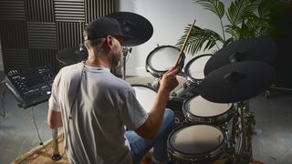 Man playing Roland TD716 electronic drum set in a studio