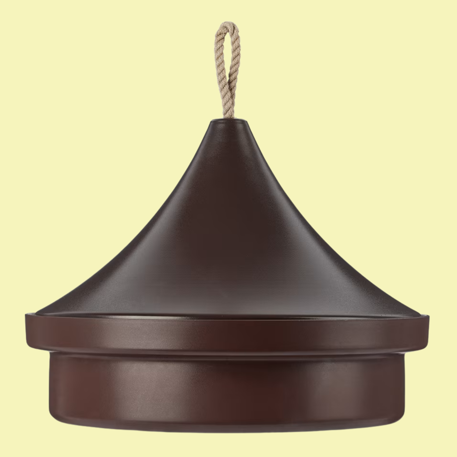 A brown tajine cooking pan by knIndustrie, against a soft yellow background