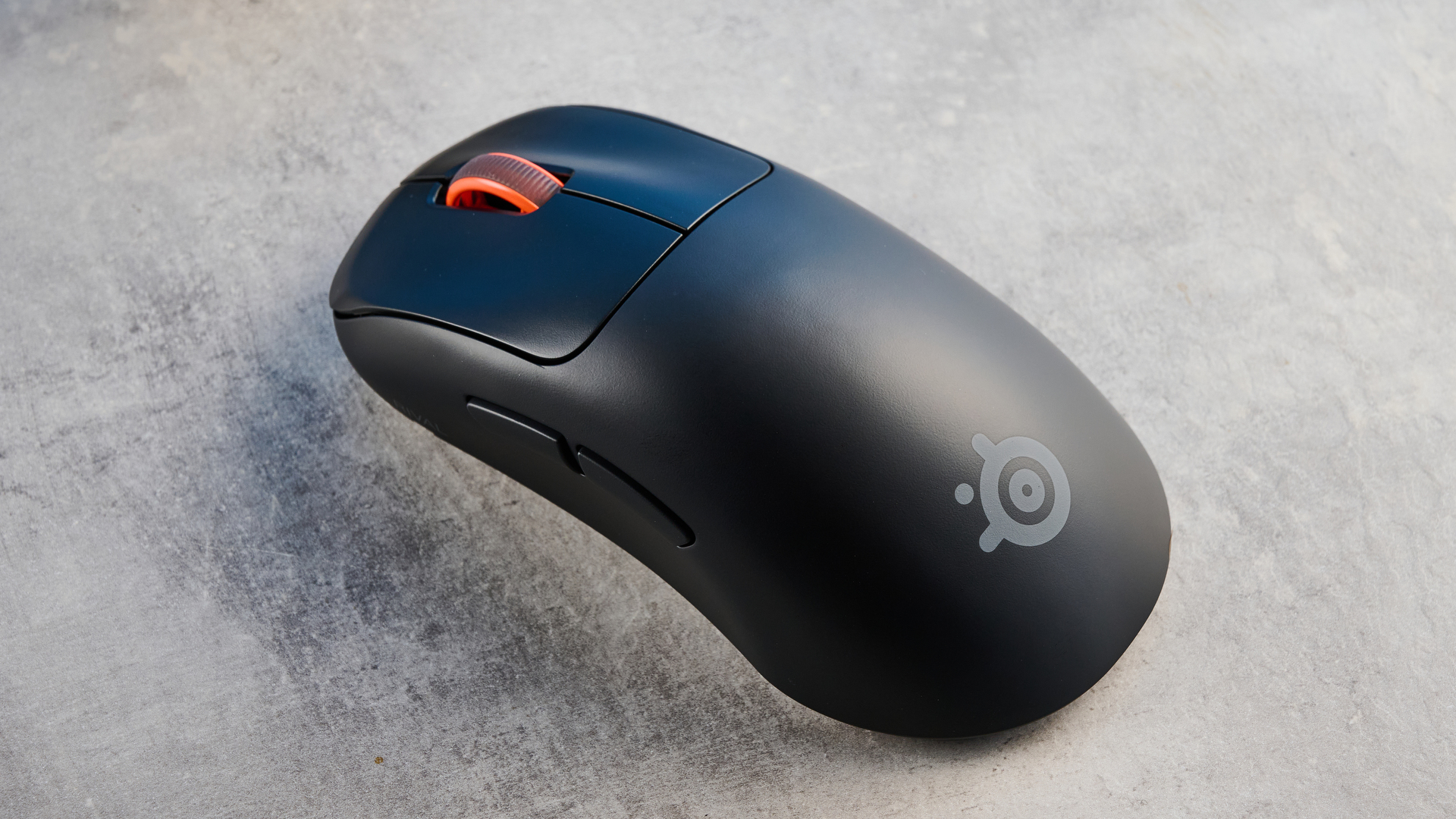 The SteelSeries Rival Pro mouse on a grey stone surface