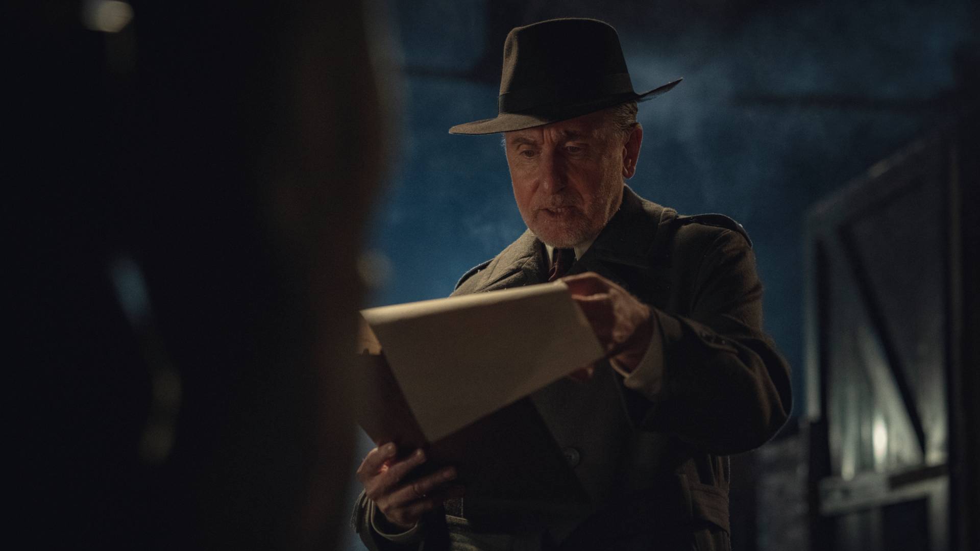 Tim Roth as Beckett reading a document in Peaky Blinders: The Immortal Man