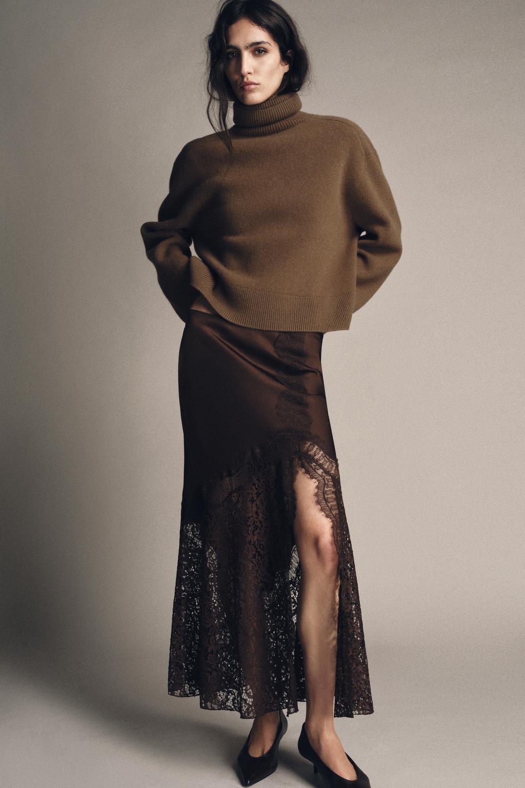 Model wears brown sweater, brown lace satin skirt, and brown kitten heel pumps.