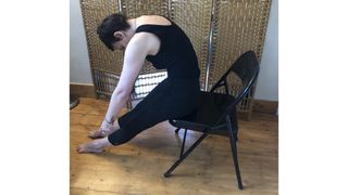 Nicola Geismar performing seated spinal stretch yoga in chair