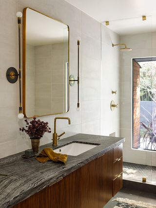 Modern bathroom with gold mirror and marble topped vanity