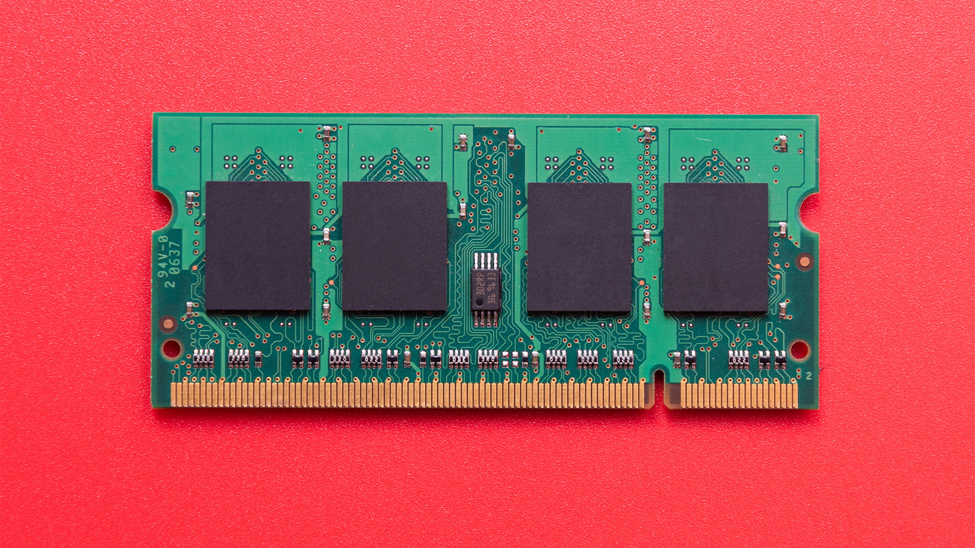 RAM computer memory chip pictured against a red background.