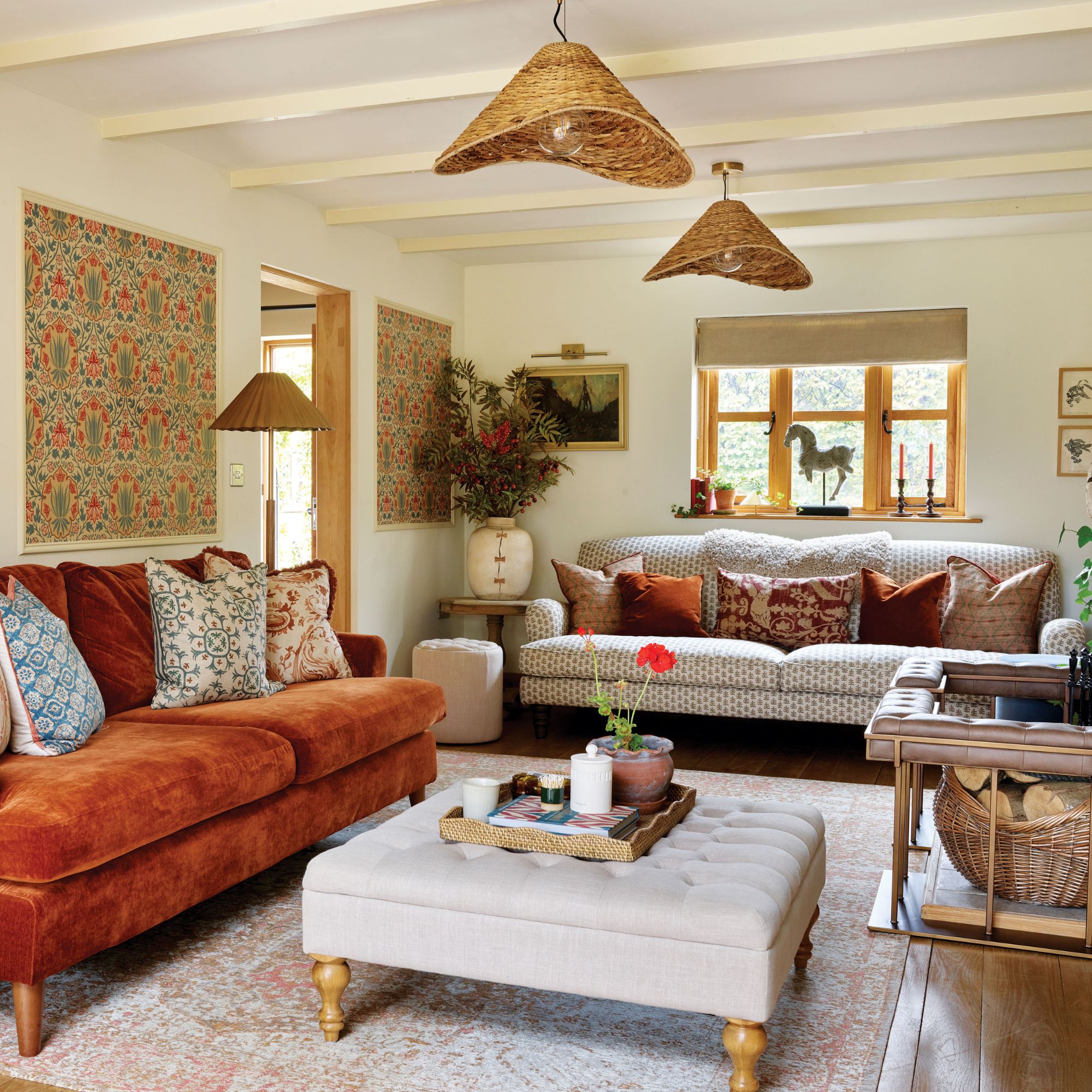 Living room with orange and red tones from sofa and cushions, with rattan lights and patterned walls