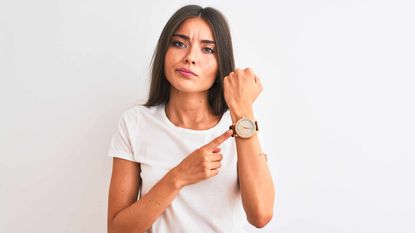 picture of impatient woman pointing to her watch