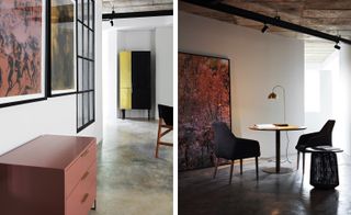 Side by side views of a studio space. Left, featuring a three draw brown cabinet, a brown painting on the wall. Right: A large forest painting on the wall next to a circular desk and two chairs. The desk has a large loop lamp.