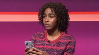 Ayo Edebiri texting during a fake game show on SNL.