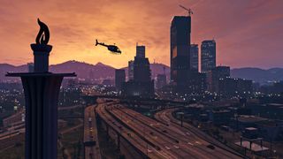 Helikopteri lentää iltahämärään verhoutuvan kaupungin yllä GTA 5:n kuvakaappauksessa.