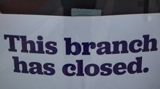 Sign saying a bank branch has closed