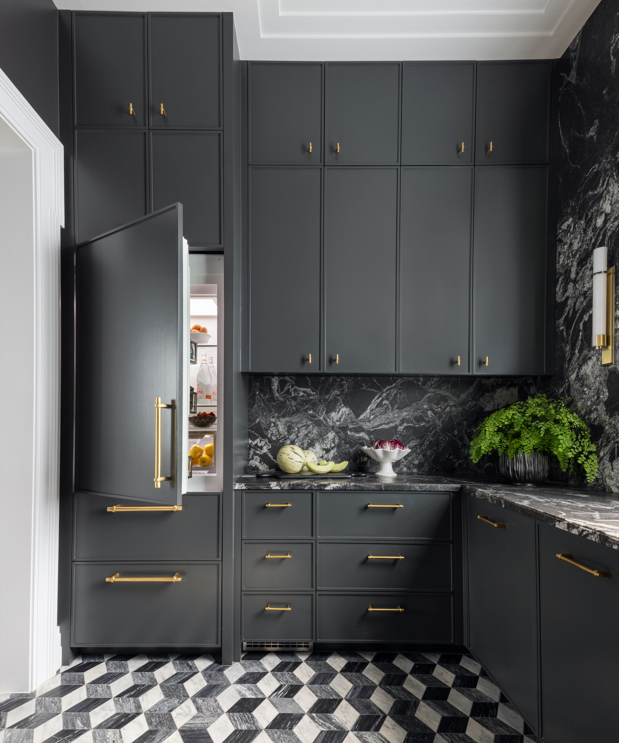 dark grey kitchen with zigzag floor tiles and dark marble and open fridge