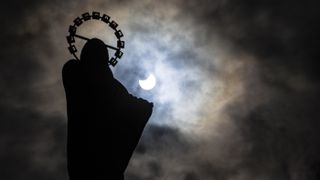 The partial solar eclipse hangs behind a statue of Our Lady, Star Of The Sea on Bull Wall in Dublin, on June 10, 2021. Skywatchers in the U.K. and Ireland saw a crescent sun instead of the “ring of fire” formed by the annular eclipse.