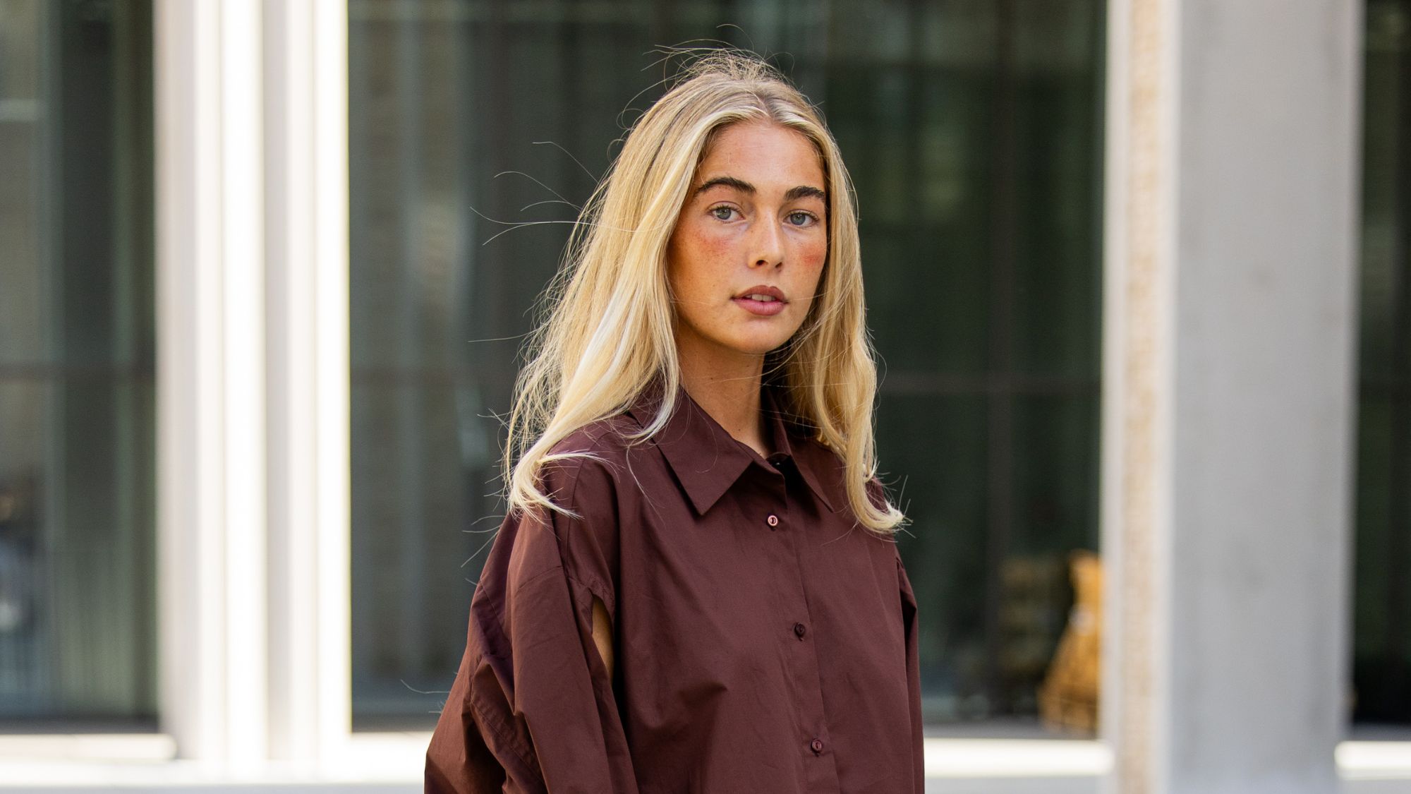 woman with blonde hair wearing a brown shirt