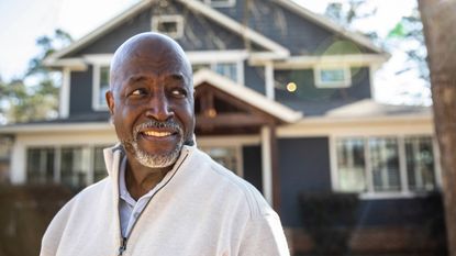 Portrait of senior man in front of his house