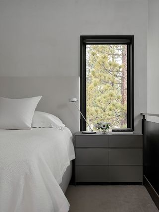 bedroom with white linen and bedhead and gray bedside table