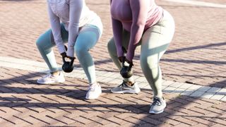 Women exercising with kettlebells outside