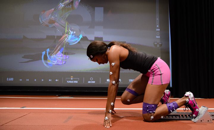 A woman wearing digital research equipment in a crouch start