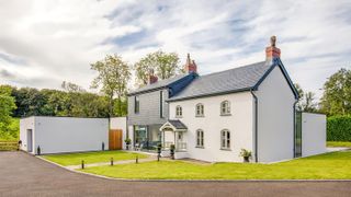 traditional white rendered house with slate hug extension