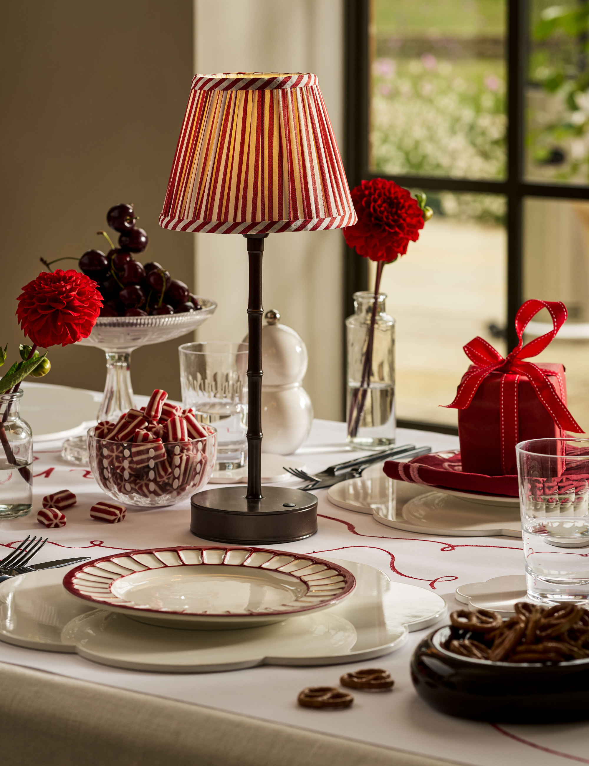 Addison Ross-designed holiday table featuring a a table lamp with a red-and-white pleated shade