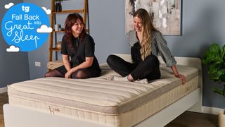 Two Tom's Guide testers sitting on the Birch Luxe mattress smiling and laughing