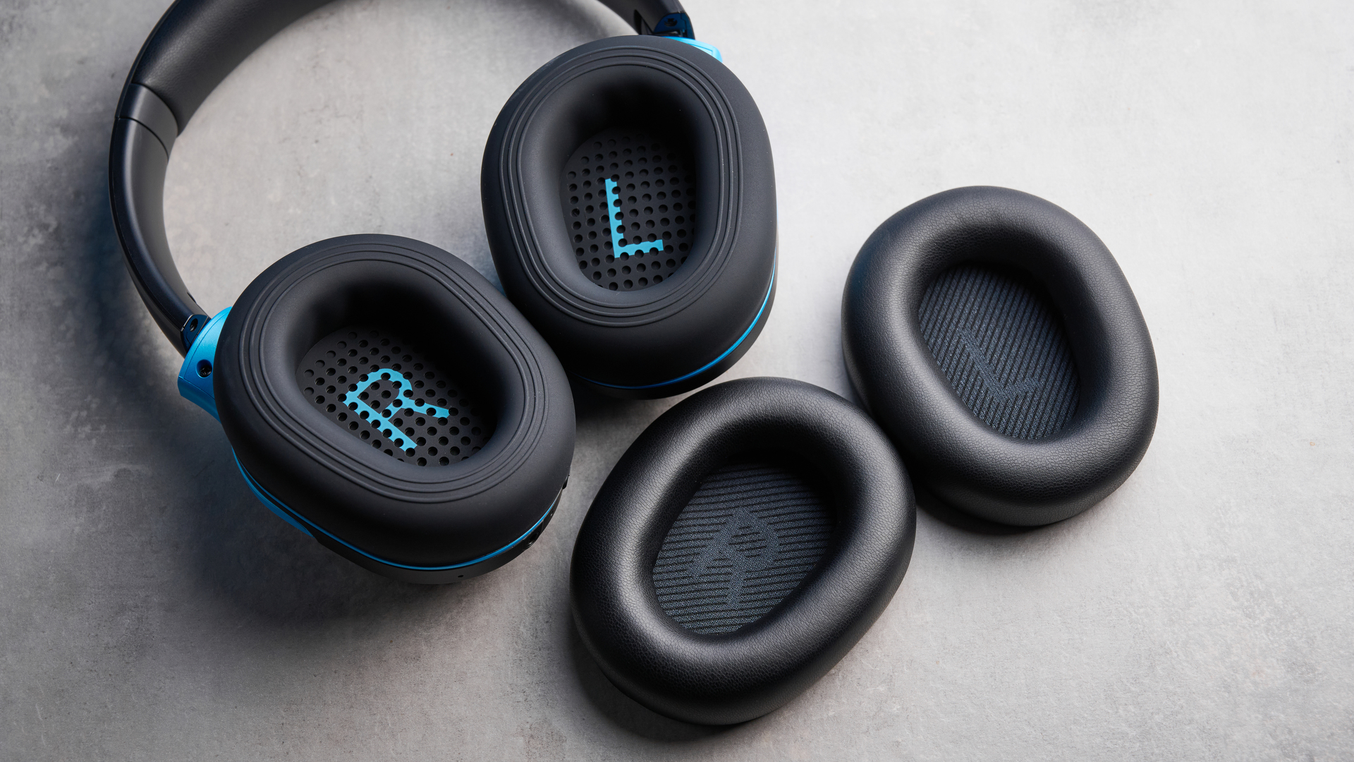 H2O RIPT Ultra headphones in black with blue accents photographed on a blue background