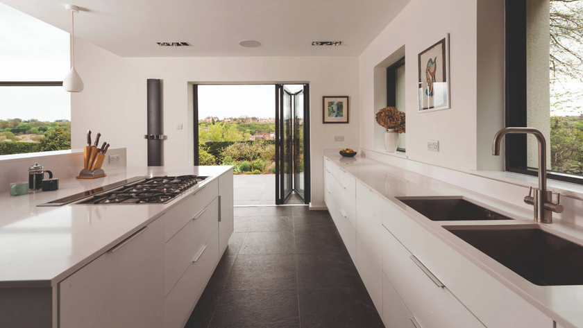 Galley kitchen idea with white cabinets and black floor