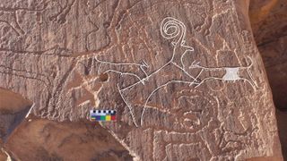 An AlUla rock art panel shows two dogs hunting an ibex.