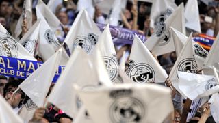 Real Madrid fans waving club flags in the crowd