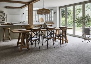 dining room with bifold doors and natural carpet