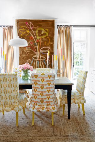 Dining chairs with slip covers in nLadder Leaf linen in Yellow/ Olive and Anna Jeffreys and Chintamani linen in Marigold, both Ottoline at The Fabric Collective