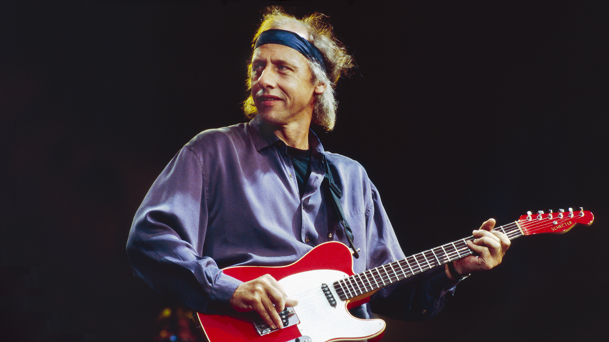 Mark Knopfler of Dire Straits performs on stage in Birmingham, 1991. He is playing a Schecter guitar.