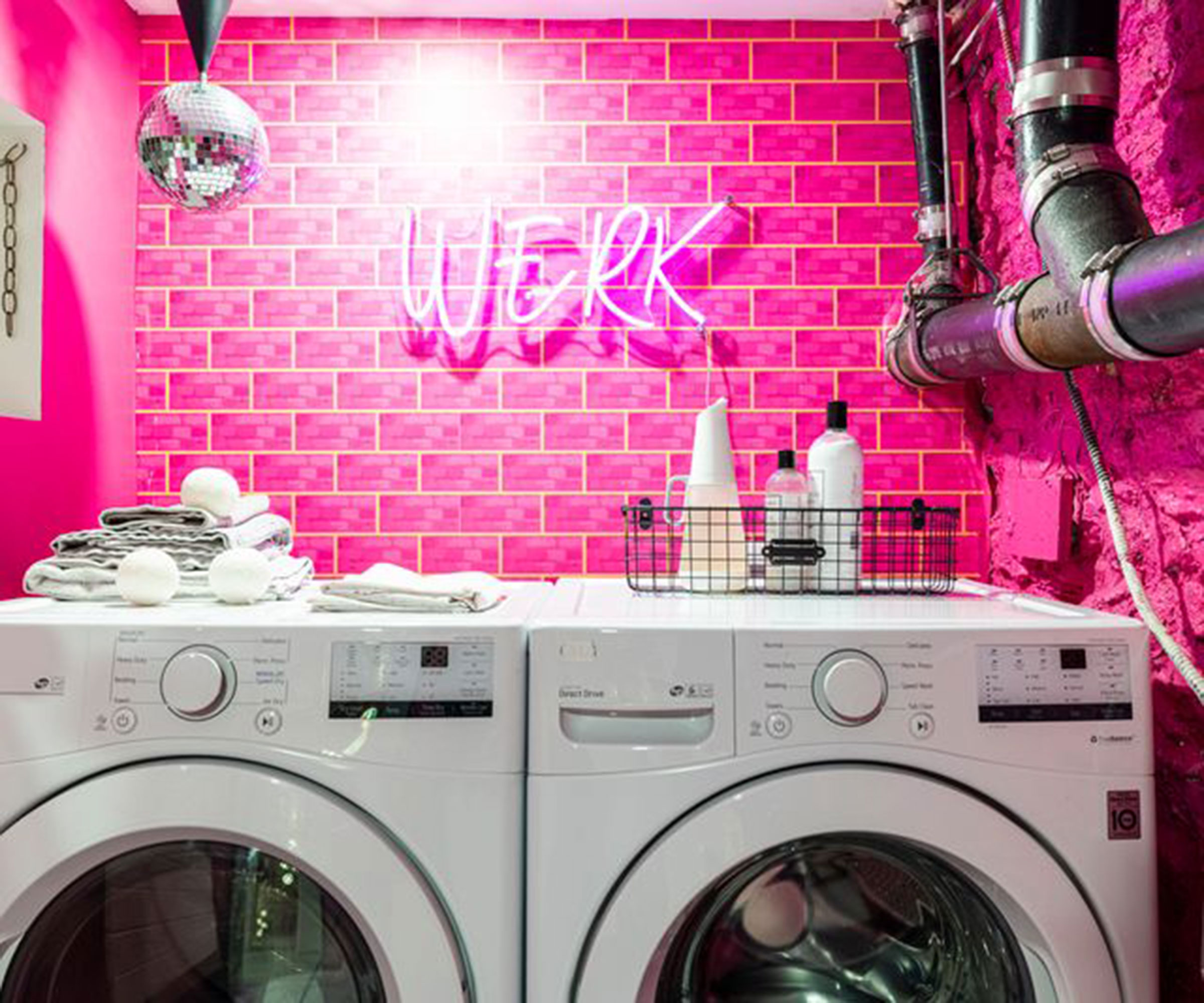 pink utility room with pink wall tiles and neon wall light with hanging disco ball