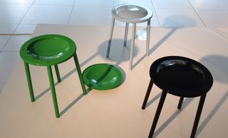 White tiled floor, white viewing platform, small shiny tables, in green, white and black