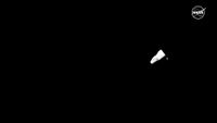 long-distance view of a conical white capsule against the blackness of space