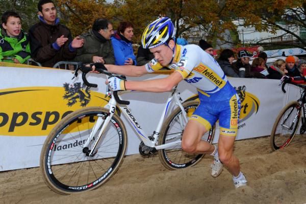 Joeri Adams runs with his bike through the sand