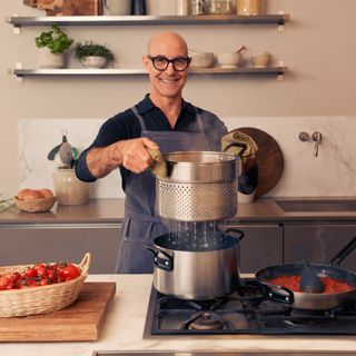 Stanley Tucci straining pasta in his TUCCI by GreenPan pot