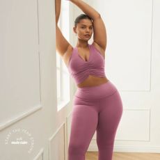 woman wearing pink sports bra and bootcut leggings from the alo yoga sale