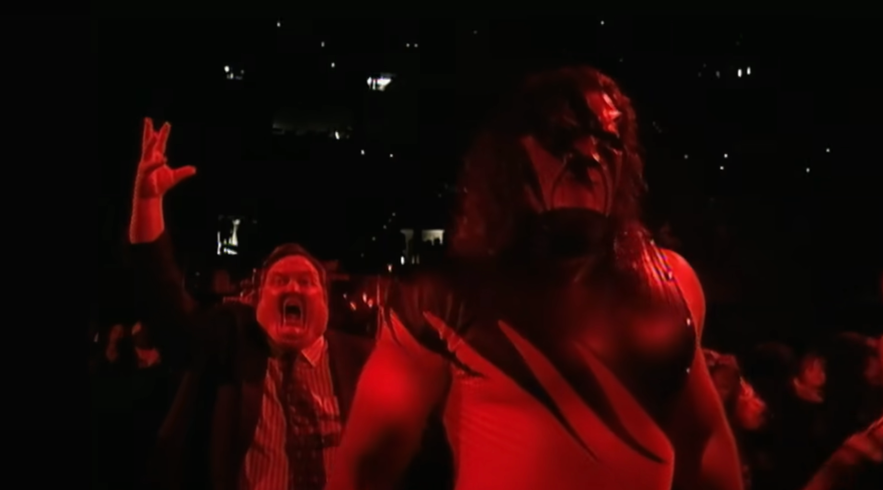 Kane walks to the ring with Paul Bearer behind him.