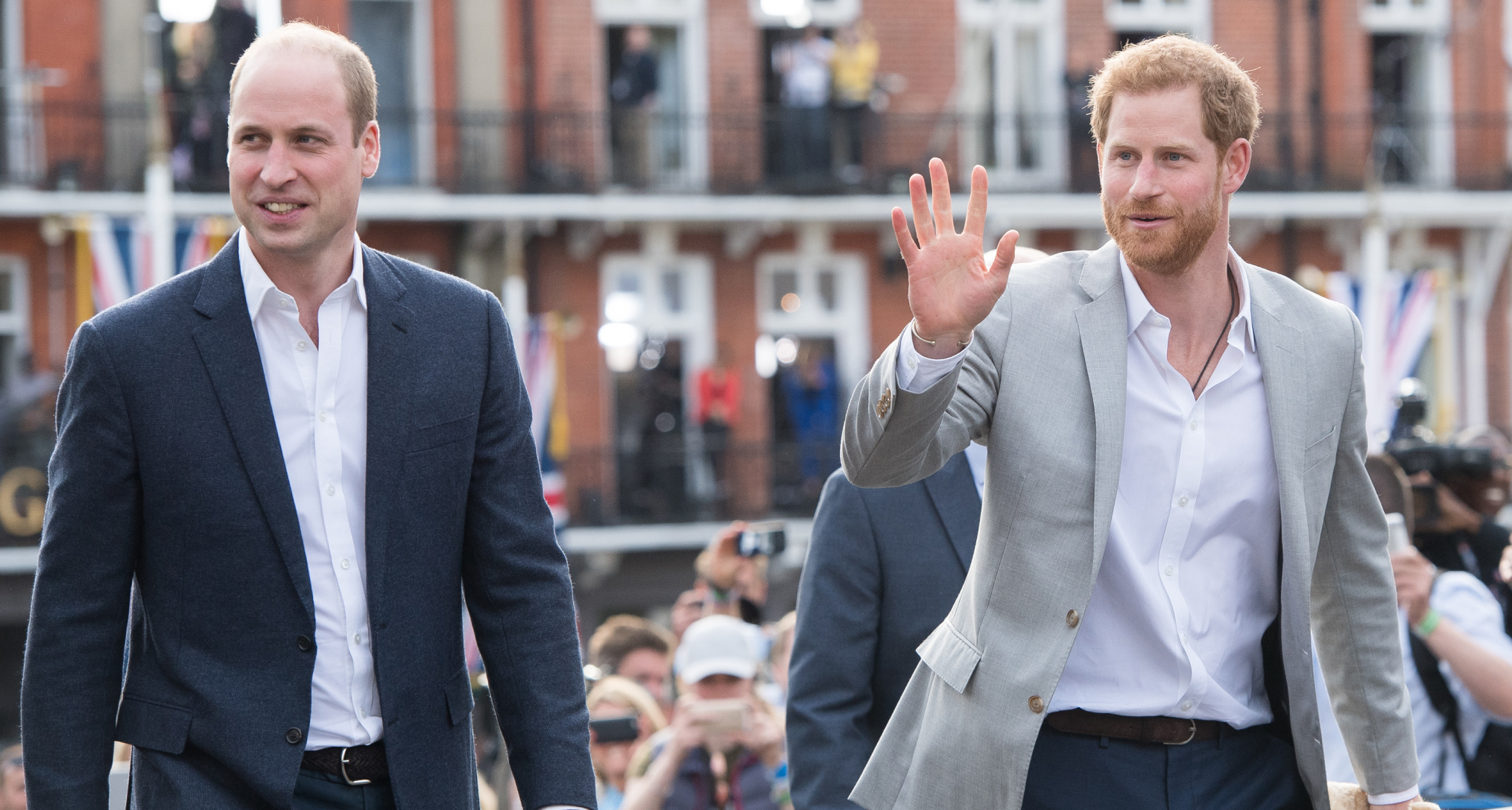 Prince William and Prince Harry walking next to each other in sport coats