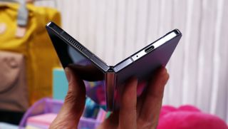 Mobilen Samsung Galaxy Z Fold 5 hålls upp i ett halvt stängt läge.