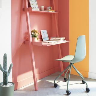 modern home office ideas, home office with pink and yellow colour blocking, desk with shelving, chair, plant