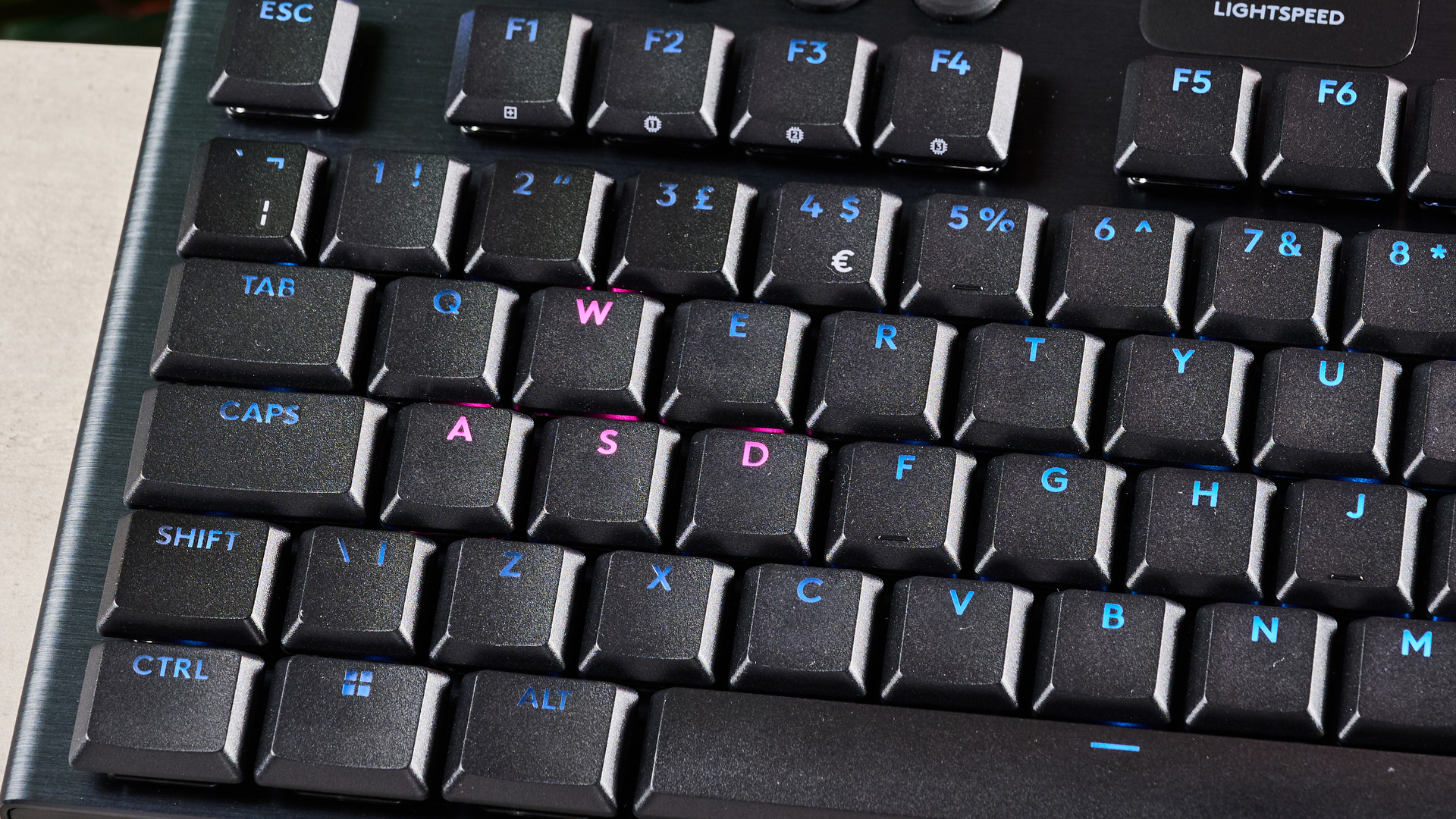 Close-up of WASD key lit in pink on Logitech G915 x