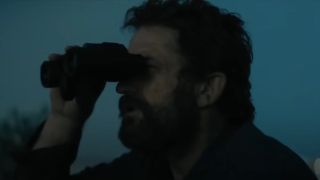 Gerard Butler checking something out through binoculars in Kandahar.