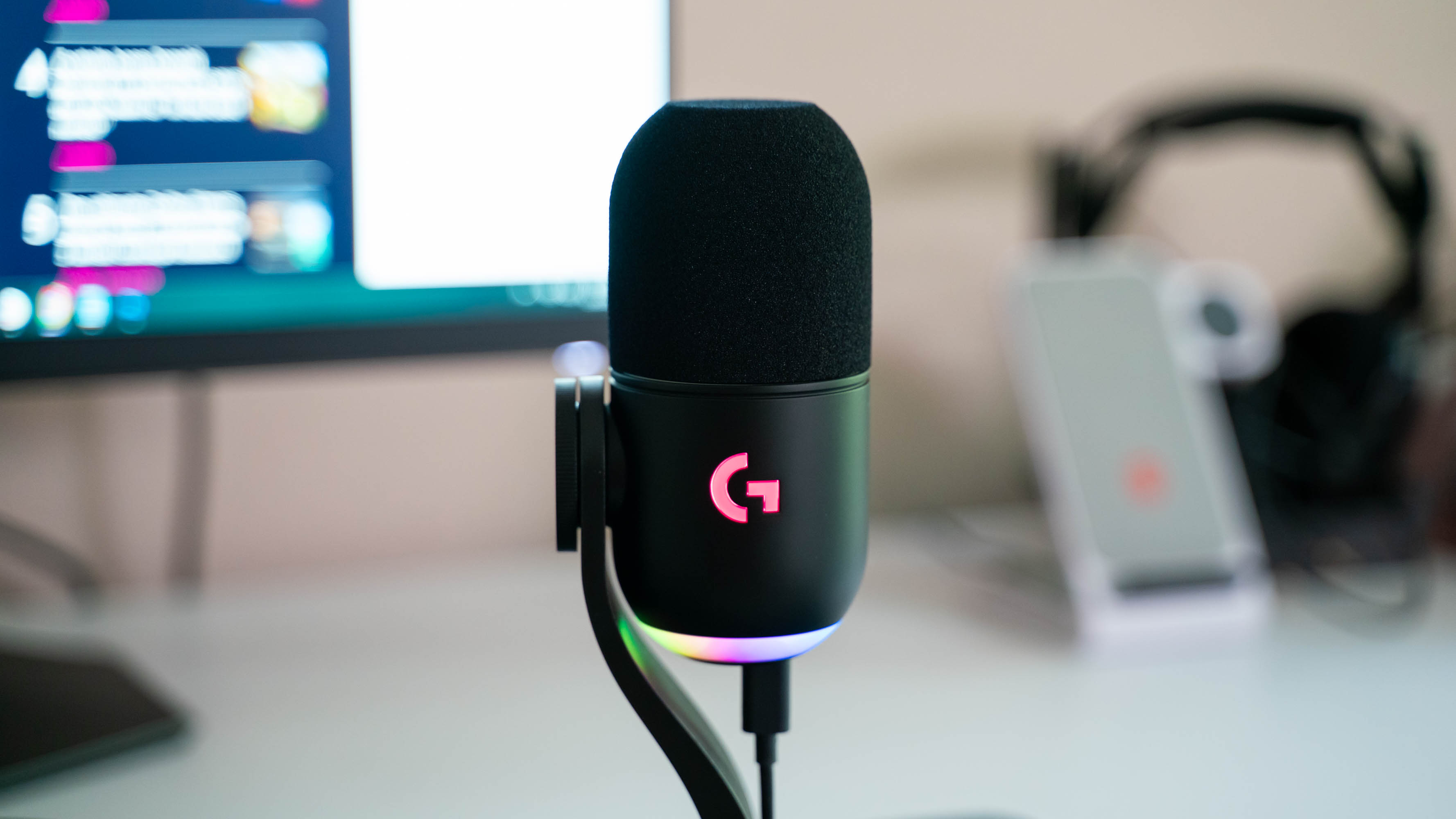 Logitech G Yeti GX on på skrivebordet med pink lys i logo