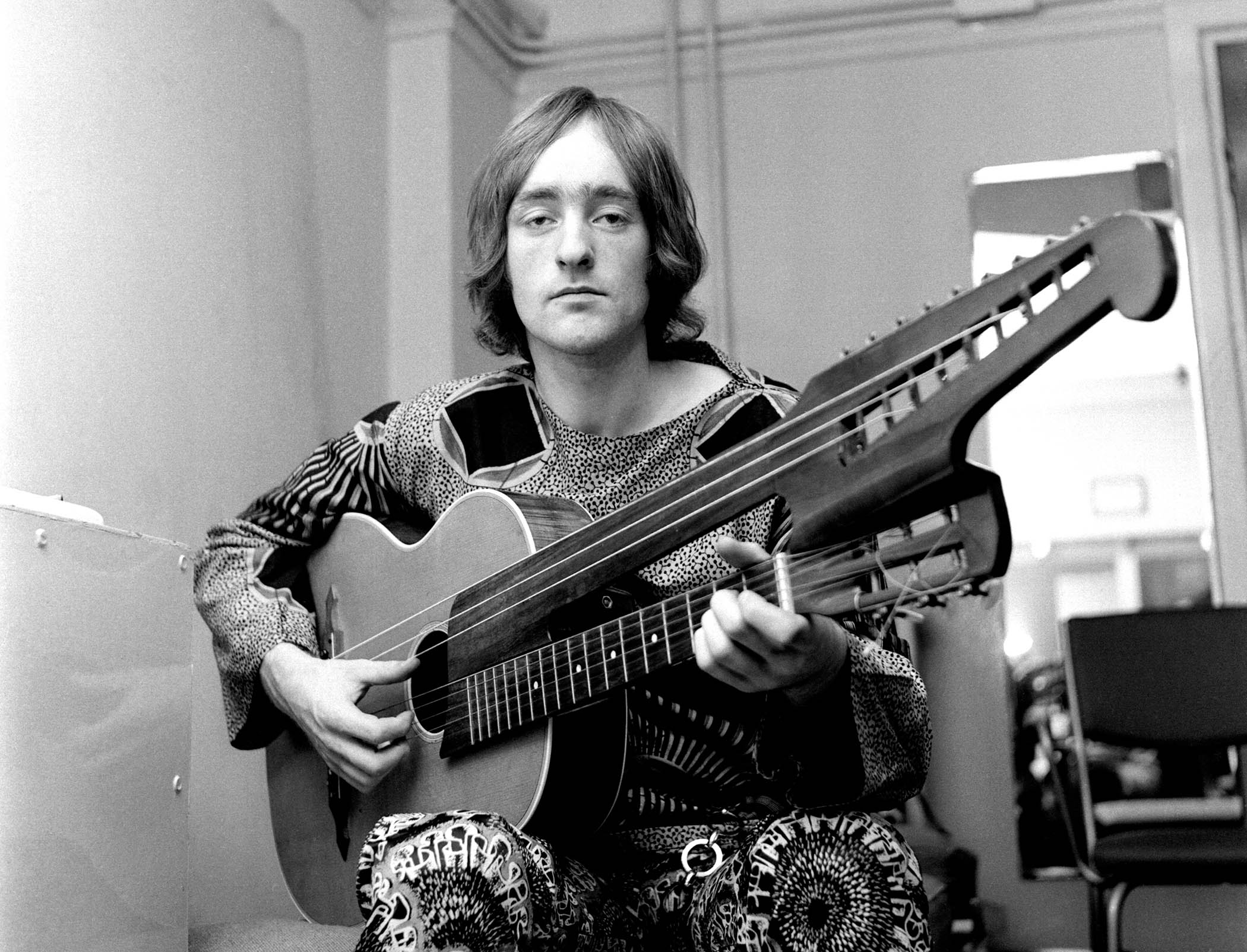 A black-and-white shot of the late Dave Mason playing a strange double-neck acoustic in 1968.