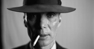 black-and-white headshot of a man in a fedora smoking a cigarette