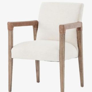 A wooden armchair with white upholstered cushions