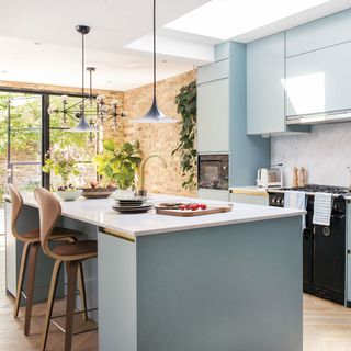 blue kitchen island with white worktop and blue cabinets and pendant lighting