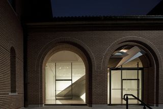 The front view of the Rice Gallery. Two arches with a red brick facade provide a view of the inside.