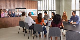 Cisco's new Room Bar Pro being used in a hybrid meeting for videoconferencing among young adults. 